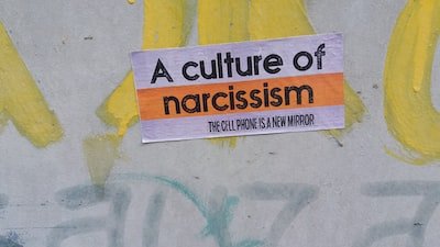 a sign on the side of a wall that says a culture of narciss