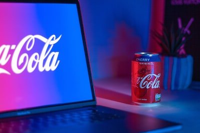 Coca-Cola soda can beside laptop